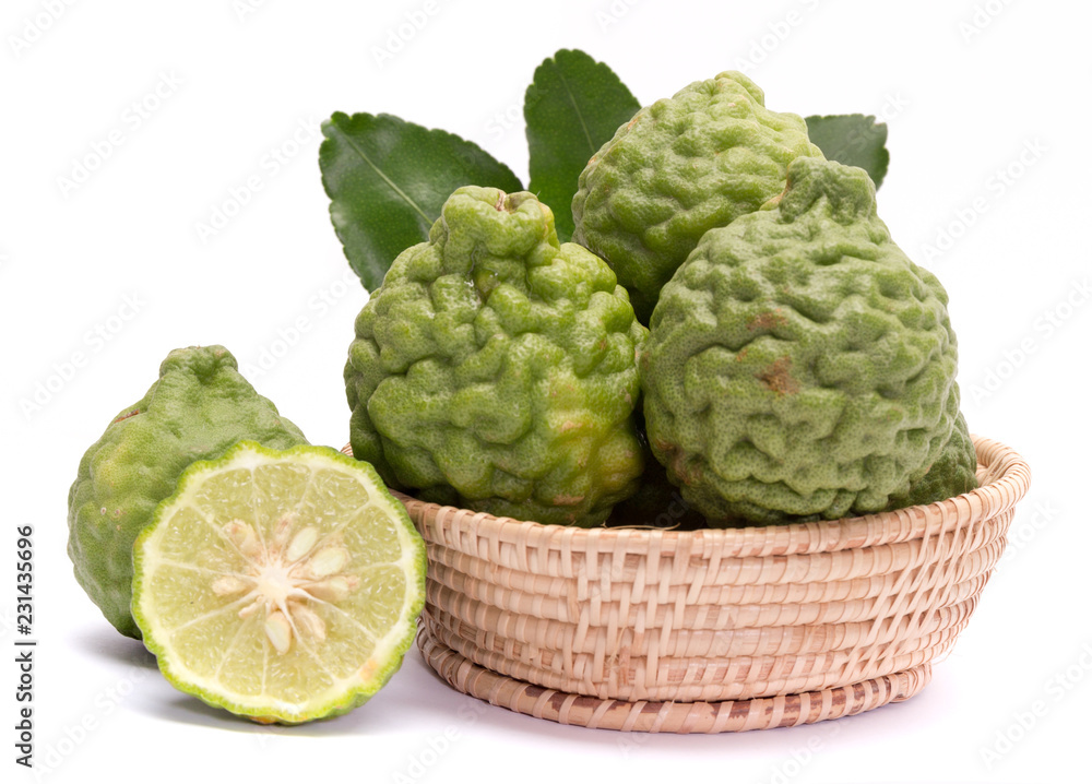 The kaffir lime leaves in the basket on a white background. The kaffir lime leaves in the basket on a white background.