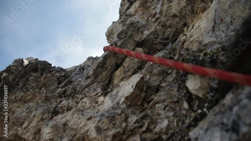Climbing rope hanging on a rock close-up. Equipment climbers in the mountains, steadicam shot.