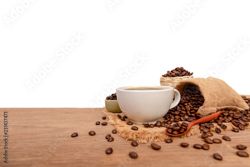 Hot cup of coffee and beans with burlap sack on the wooden table, with copy space