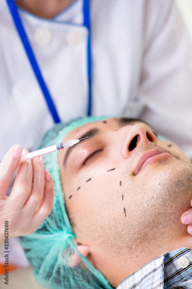 Plastic surgeon preparing for operation on man face Plastic surgeon preparing for operation on man face