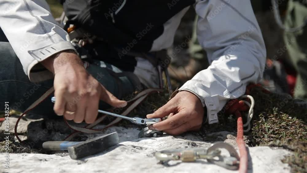 Close-up of the man's hand twisting the key bolt into the rock. Organization of insurance for rescue work. Close-up of the man's hand twisting the key bolt into the rock. Organization of insurance for rescue work.