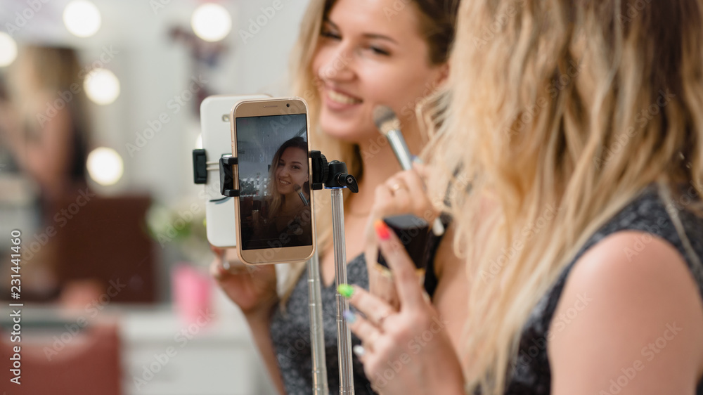 Professional beauty blogger broadcasting cosmetic makeup by smartphone Professional beauty blogger broadcasting cosmetic makeup by smartphone