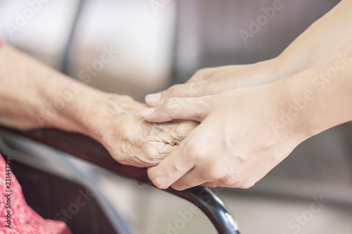 Hand of  eldery  woman with her caregiver at home. Home care or Elderly care concept. © chompoo