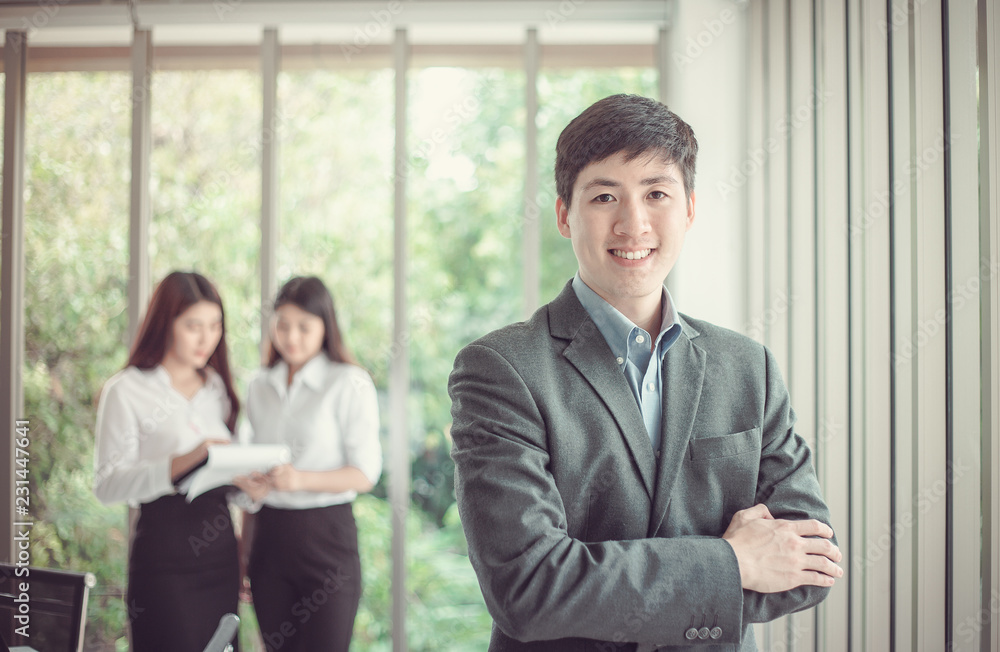 Smiling Businessman on the background of business people working in office. Smiling Businessman on the background of business people working in office.