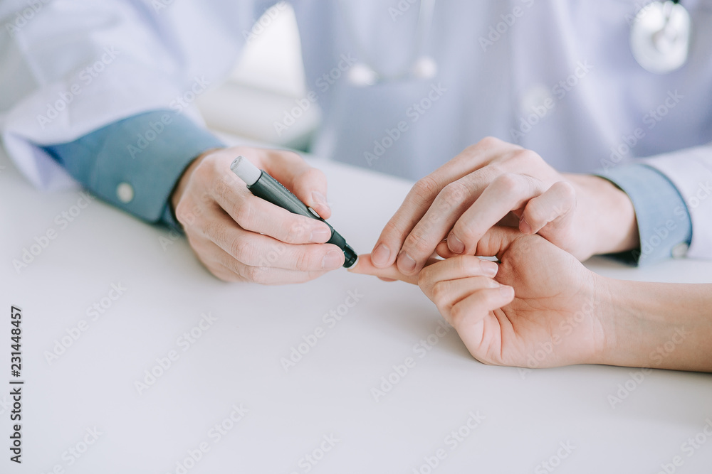 Doctor or technicain checking the blood-sugar level in the hospital room. Doctor or technicain checking the blood-sugar level in the hospital room.