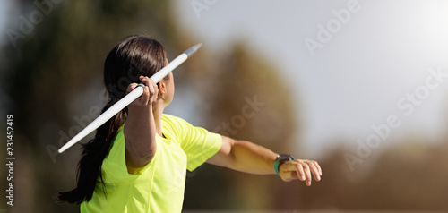 Foto Female athlete throwing a javelin, rear view