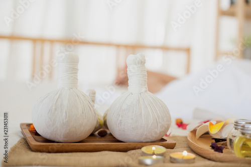 Selective focus Herbal compress balls with oil, on the wooden table in spa salon. alternative medicine and relaxation Concept.
