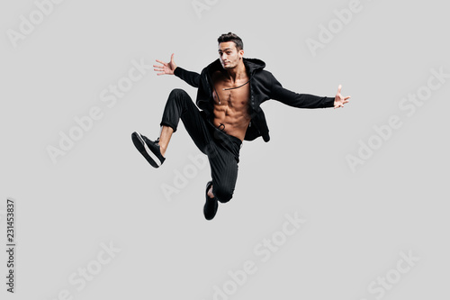 Fotografie Handsome dancer of street dancing dressed in black pants and a sweatshirt on a n