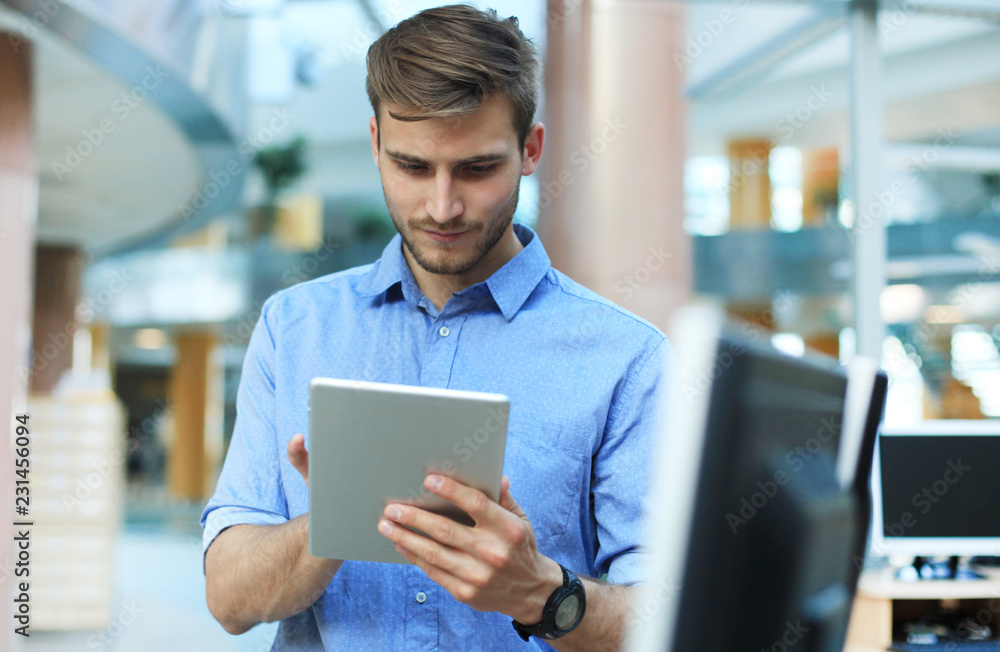 Young man using his tablet in the office. Young man using his tablet in the office.
