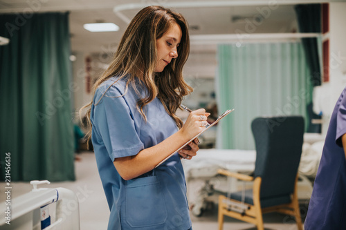 Young female nurse taking notes