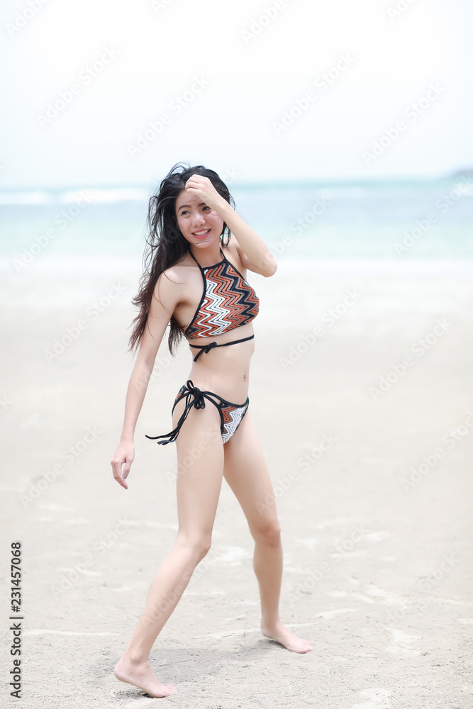 Portrait of pretty beautiful sport fashion woman in bikini posing in summer near the sea and blue sky in sunshine with gorgeous smile in happy mood on tropic island on vacation Portrait of pretty beautiful sport fashion woman in bikini posing in summer near the sea and blue sky in sunshine with gorgeous smile in happy mood on tropic island on vacation