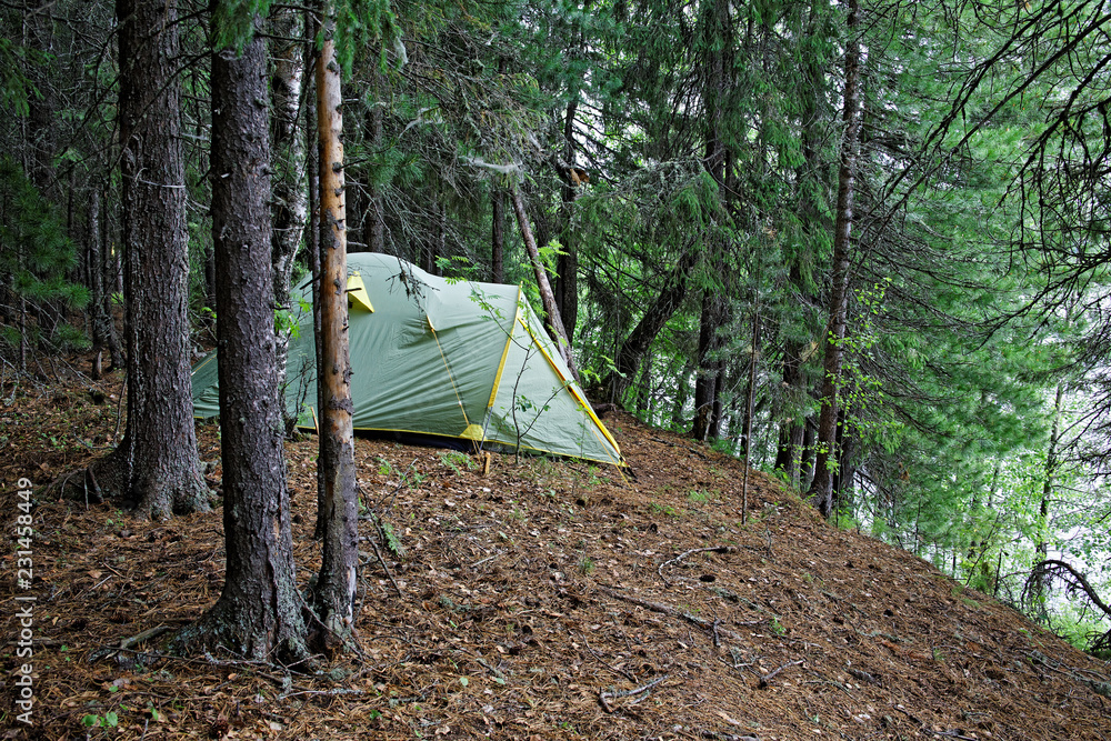 Tent installed on the steep bank of a wild Siberian river