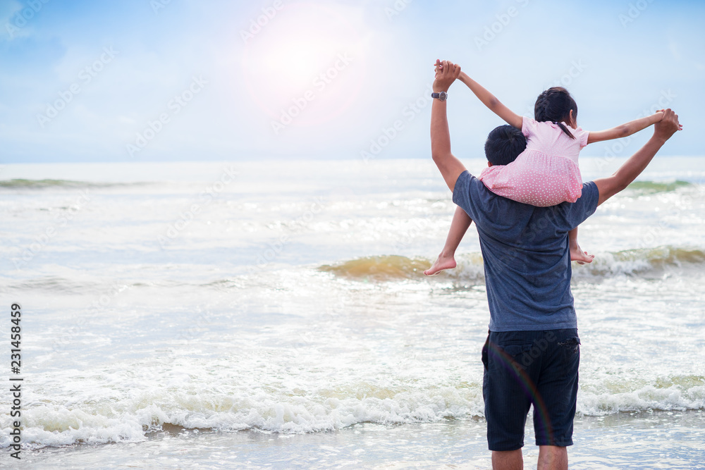 Daughter riding father neck on the beach.Family concept Daughter riding father neck on the beach.Family concept