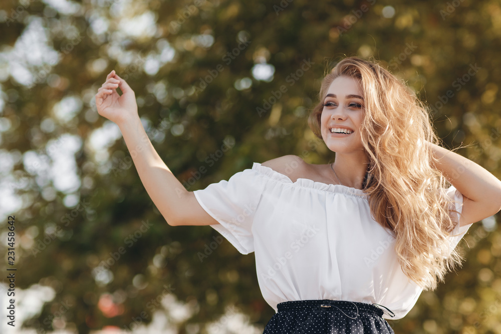 Beautiful young woman outdoors in the park in spring.Beautiful Young Woman Enjoying nature Outdoor. Happy and Healthy Smiling brunette Girl with healthy smile relaxing in the Summer Park. Breathing fr Beautiful young woman outdoors in the park in spring.Beautiful Young Woman Enjoying nature Outdoor. Happy and Healthy Smiling brunette Girl with healthy smile relaxing in the Summer Park. Breathing fr