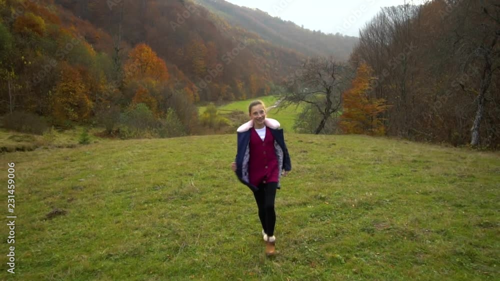Beautiful girl runs through the autumn forest. She is happy and laughing. She flirts on camera. Shooting with steadicam. Slow motion. Beautiful girl runs through the autumn forest. She is happy and laughing. She flirts on camera. Shooting with steadicam. Slow motion.