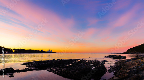 The lighthouse an shoreline of Langesund Norway with a colorfull sky at sunrise