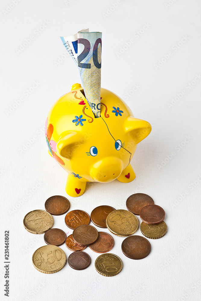 Porcellino salvadanaio con monete su fondo bianco. Stock Photo
