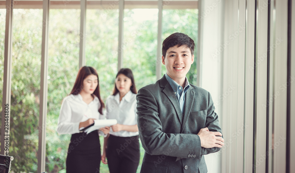 Smiling Businessman on the background of business people working in office. Smiling Businessman on the background of business people working in office.