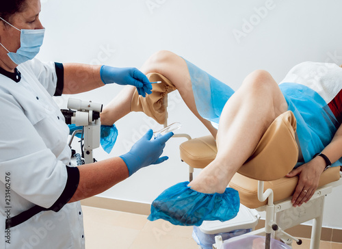 Woman in gynecological chair during gynecological check up with her doctor. Gynecologist examines a woman.