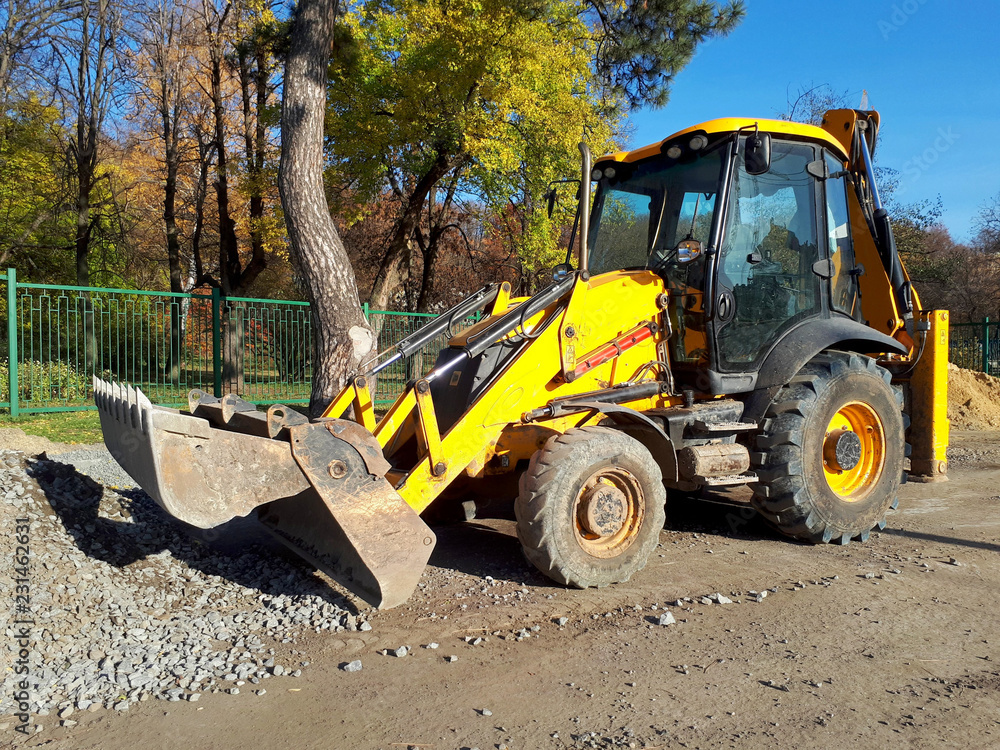 Yellow excavator collects gravel from the ground, construction work Yellow excavator collects gravel from the ground, construction work