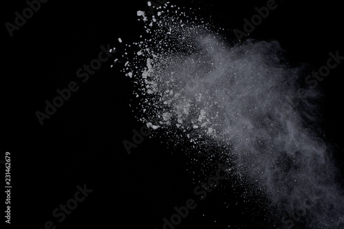 White powder explosion on black background. Dust splatted isolated. Paint Holi.