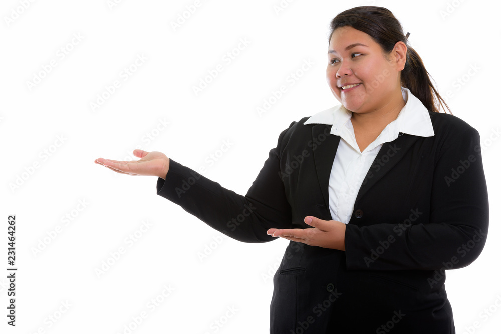 Studio shot of young happy fat Asian businesswoman smiling and s Studio shot of young happy fat Asian businesswoman smiling and s