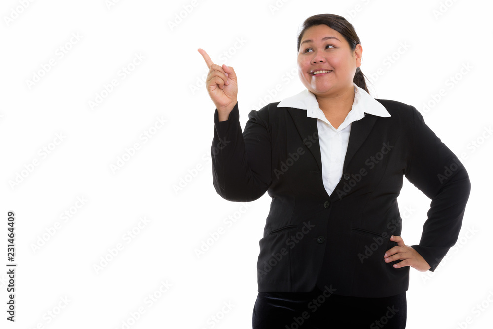 Studio shot of thoughtful young happy fat Asian businesswoman sm Studio shot of thoughtful young happy fat Asian businesswoman sm