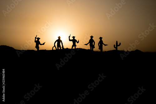 Cowboy concept. Silhouette of Cowboys at sunset time. Cowboys silhouettes on a hill with horses. © zef art