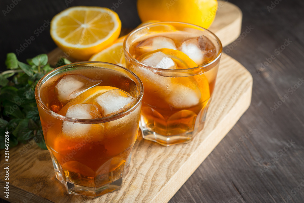 Glasses of cold ice tea with lemon, ice, mint on background. Homemade lemonade. Spring and summer drinks and beverages concept. Glasses of cold ice tea with lemon, ice, mint on background. Homemade lemonade. Spring and summer drinks and beverages concept.