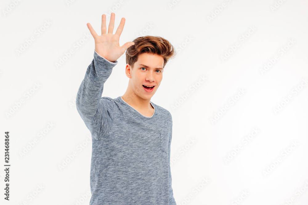 Smiling young guy welcomes saying goodbye to hand on white background Smiling young guy welcomes saying goodbye to hand on white background