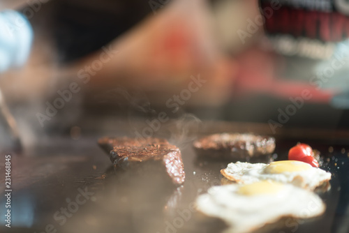 Cutlets from minced meat roasted on the grill. chicken eggs and tomatoes on the grill. breakfast in restaurant