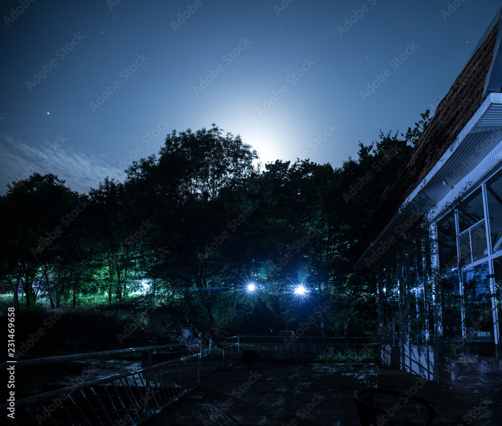 Mountain night landscape of building at forest at night with moon or vintage country house at night with clouds and stars. Summer night. Mountain night landscape of building at forest at night with moon or vintage country house at night with clouds and stars. Summer night.