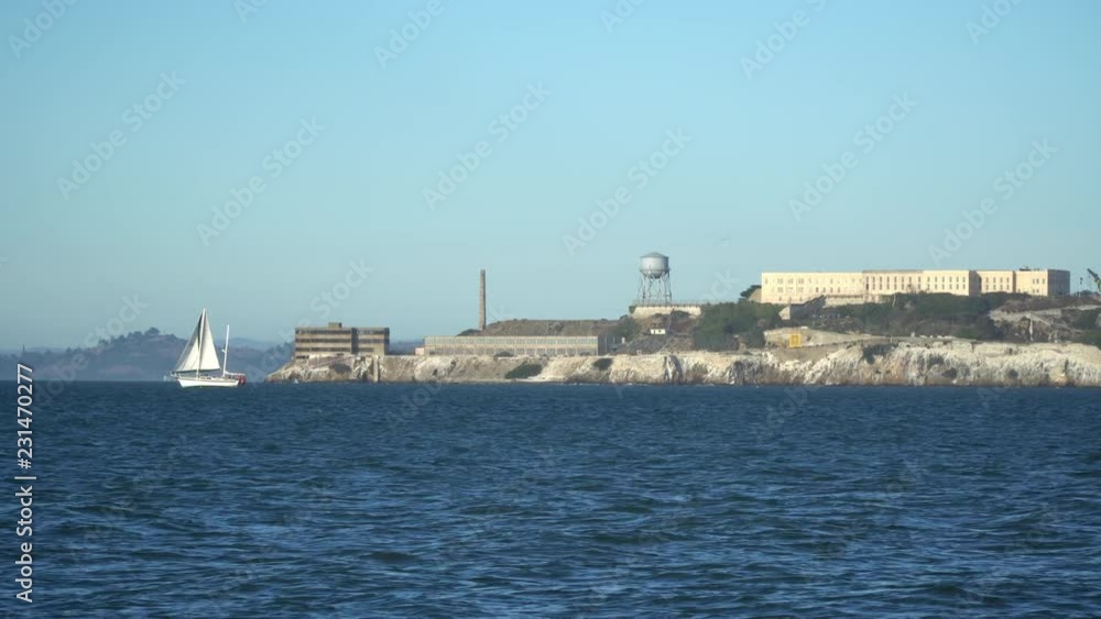 A double masted sail boat cruises in front of Alcatraz Island in San Francisco Bay. A double masted sail boat cruises in front of Alcatraz Island in San Francisco Bay.