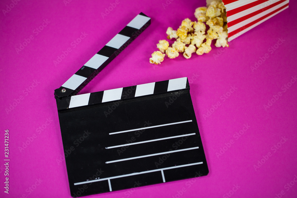 Film flap with popcorn on a pink background
