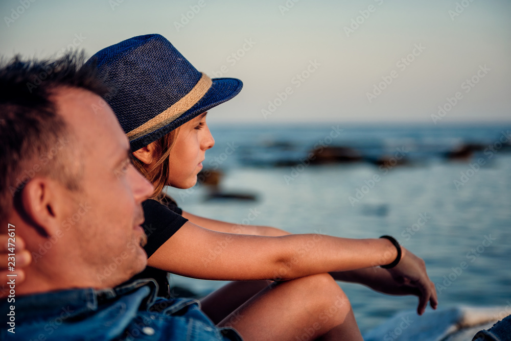 Father and daughter on beach looks into horizon Father and daughter on beach looks into horizon