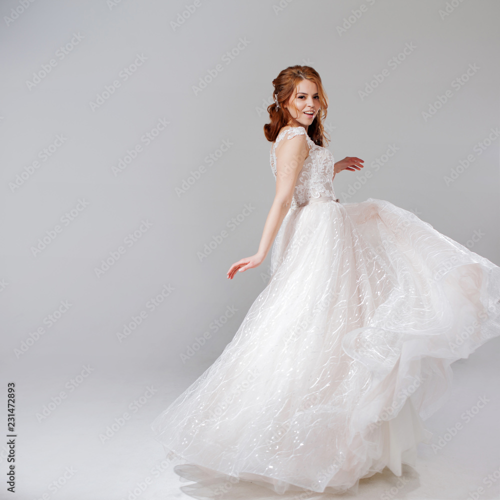 Lovely young woman bride in lavish wedding dress. Light background. Lovely young woman bride in lavish wedding dress. Light background.
