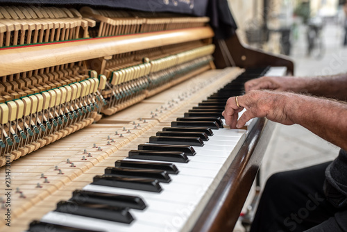 Old man hands playing on piano (shallow DOF)