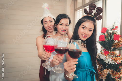 Young Women Having Fun in Celebration Christmas Party Together While Holding Red Wine Glass, Portrait of Asian Girl Teenagers are Happiness in Holiday X'Mas Party. Holiday Celebrating Event