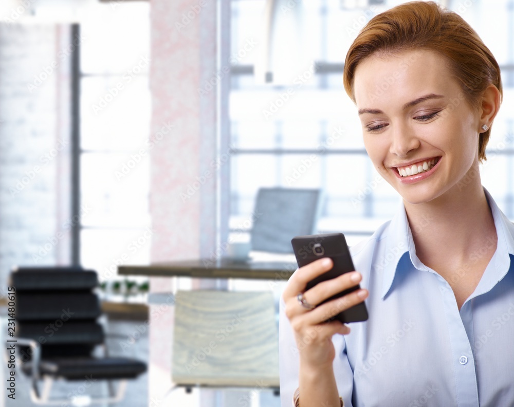 Young businesswoman using mobilephone at office Young businesswoman using mobilephone at office