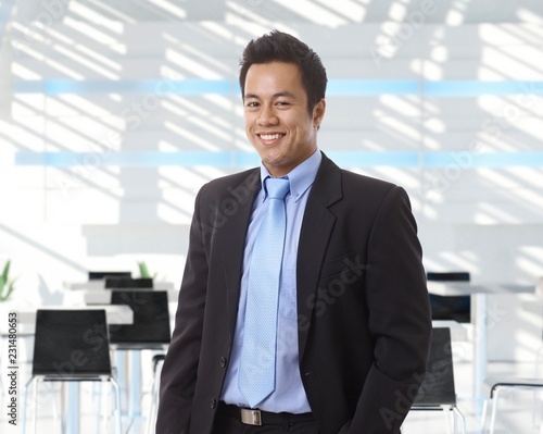Happy asian businessman at office lobby
