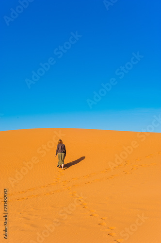 Girl walk in Erg Chebbi Desert  Sahara Desert near Merzouga  Morocco