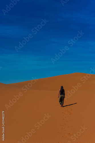 Girl walk in Erg Chebbi Desert  Sahara Desert near Merzouga  Morocco