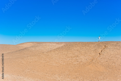 Man talking on the phone on a dune, Merzouga, Morocco