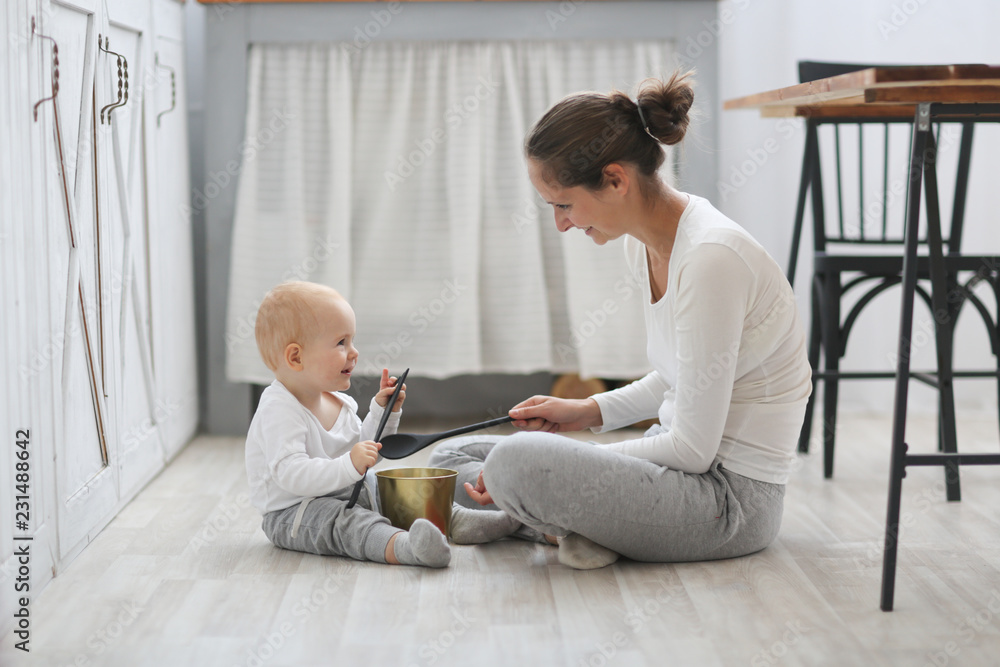 Mom and baby playing together on the kitchen floor Mom and baby playing together on the kitchen floor