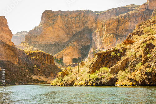 Canyon Lake east of Phoenix in Arizona is surrounded by sheer red and orange cliffs that meet the Lakes shores. Vegetation also grows in this desert wilderness area