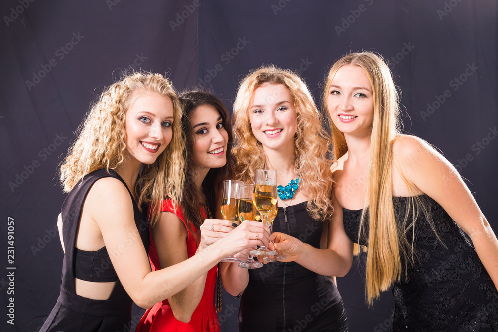 Party, holidays, celebration and new year eve concept - Cheerful young woman clinking glasses of champagne at the party Party, holidays, celebration and new year eve concept - Cheerful young woman clinking glasses of champagne at the party
