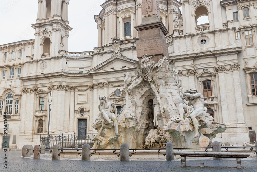 Empty Navona Square with historic Fountain of the Four Rivers and church of Sant'Agnese in Agone. Rome, Italy. 