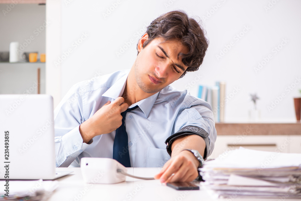 Man under stress measuring his blood pressure Man under stress measuring his blood pressure
