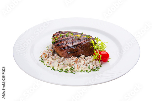 Beef steak with forest mushrooms. On a white plate