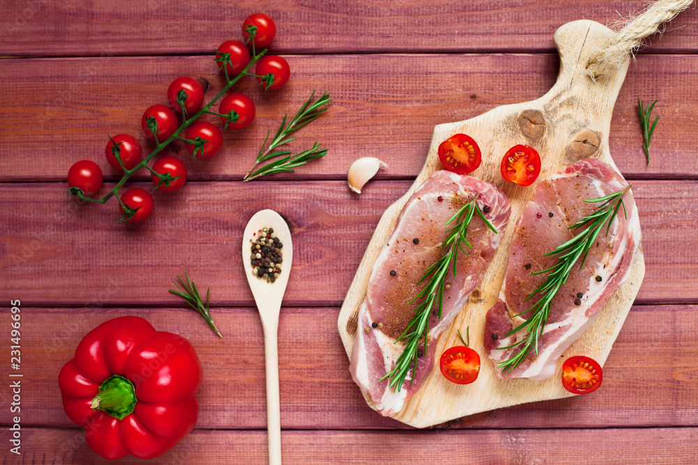 Fresh raw pork on the cutting board with ingredients for cooking. Food, flat lay, recipes and nutrition concept. Top view. Close up.